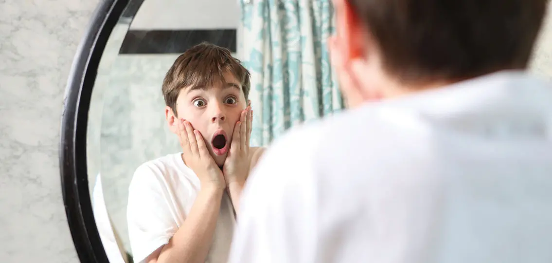 Shocked boy in mirror reminiscent of Home Alone