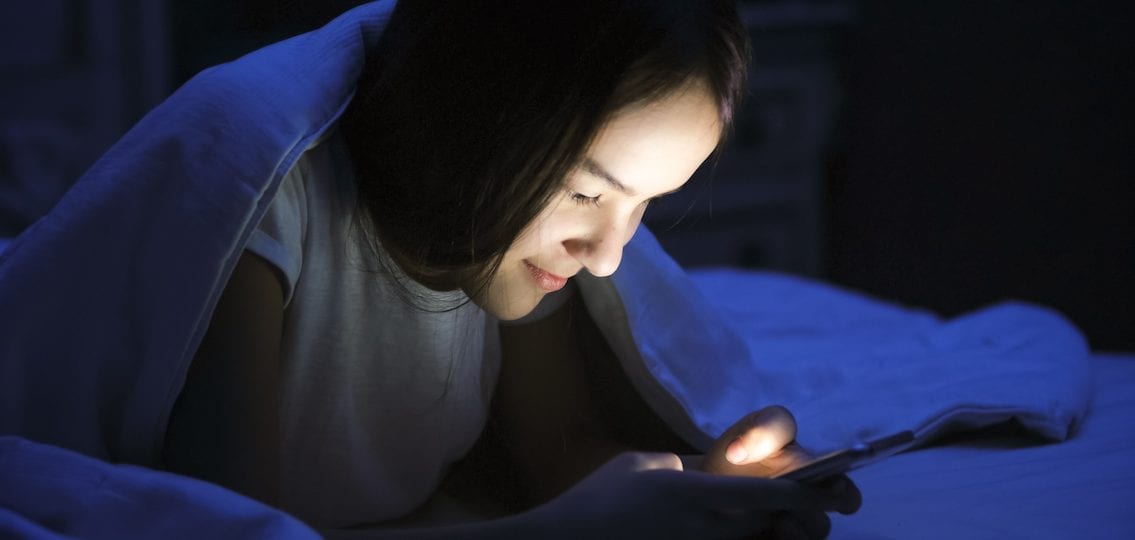 Teen girl texting at night