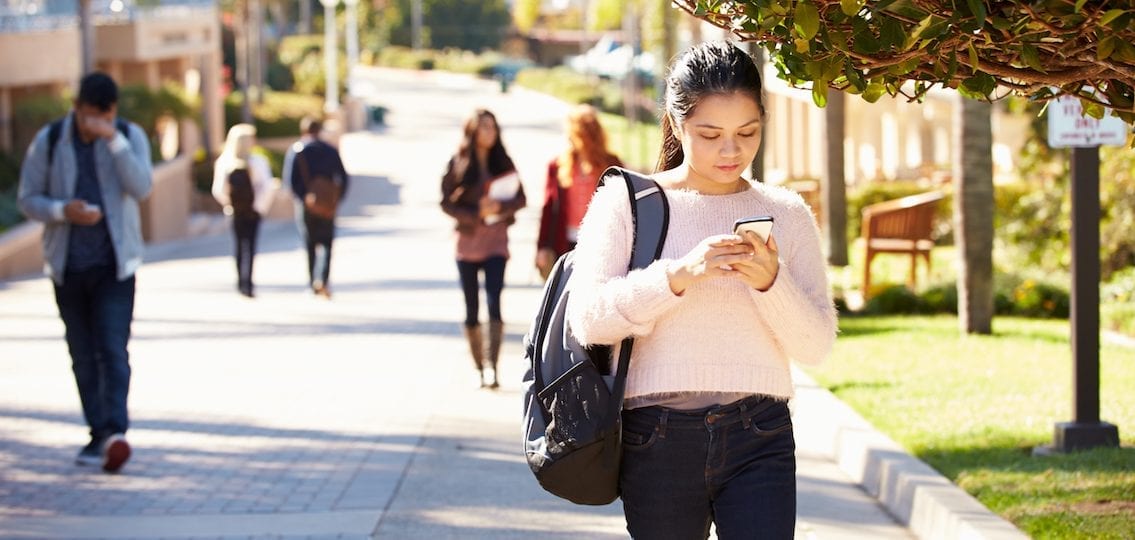 Teen girl using social media outside