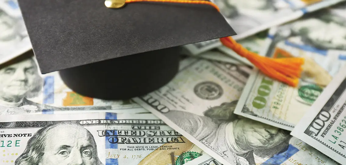 Close Up View Of Graduation Hat On Dollar Banknotes.