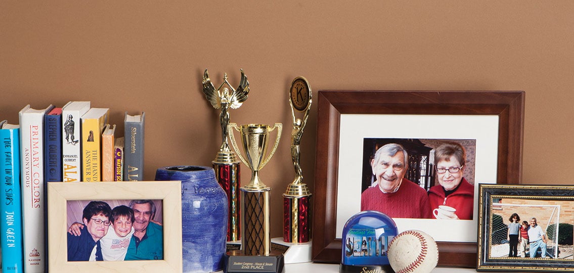 Mantle With Grandparent Memories multiple pictures and trophies