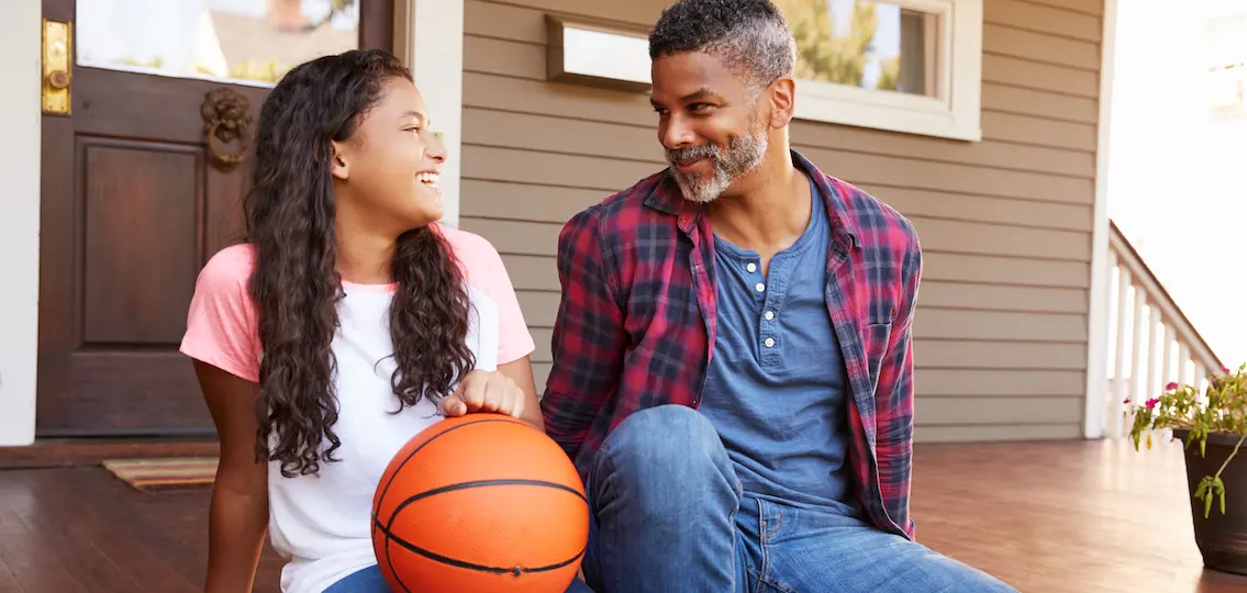 Dad and daughter bonding over a basketball