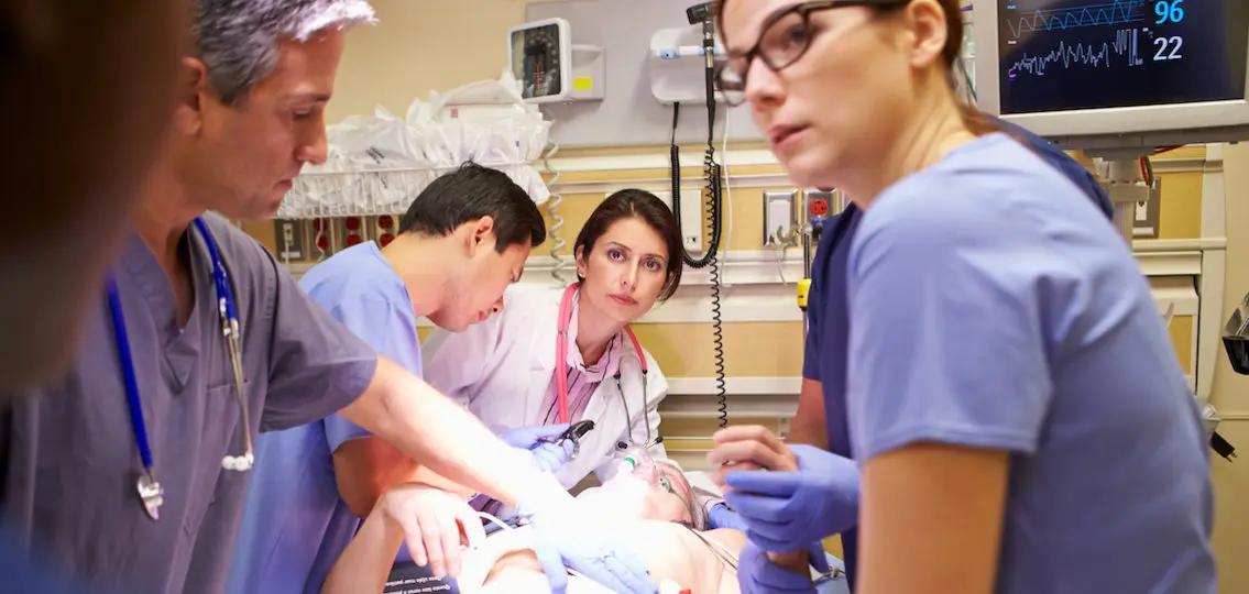 Teenager in the ER being resuscitated by a team of doctors