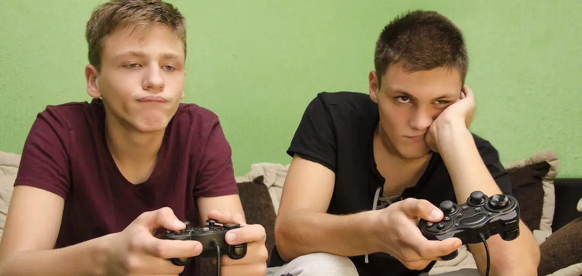 bored teen boys playing video games in a green room