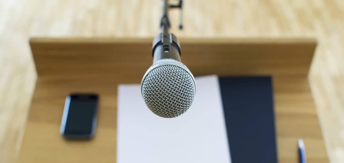 public speaking speech and close up microphone at a podium