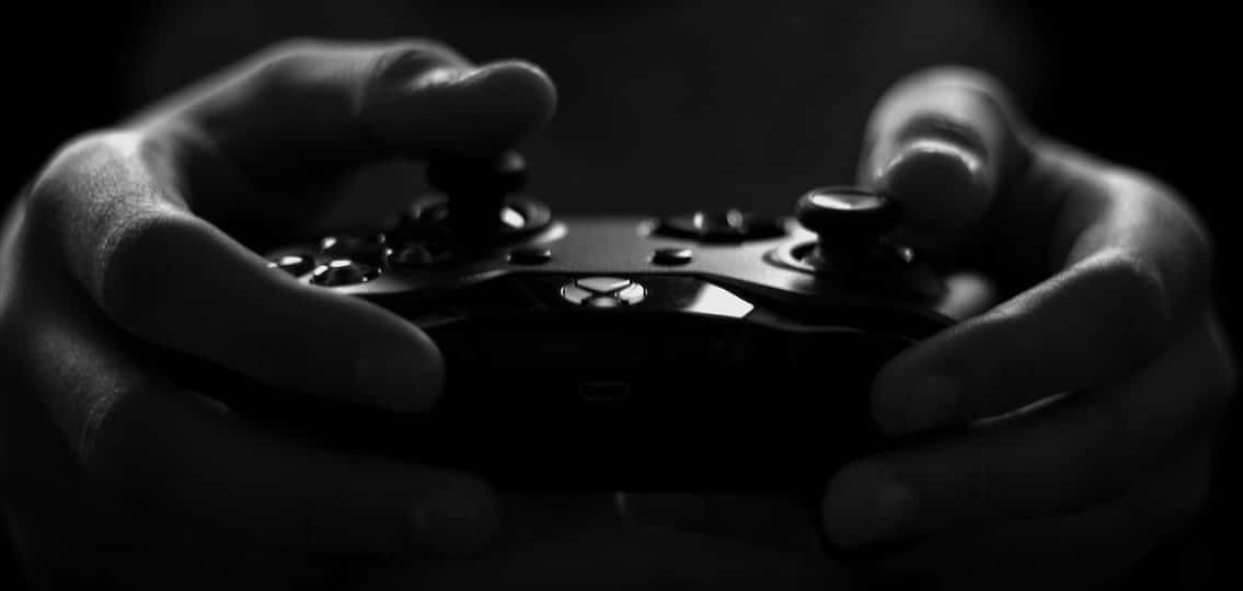 close up of a hand gaming with a video game controller