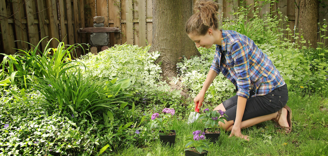 teenage girl gardening in the backyard and smiling