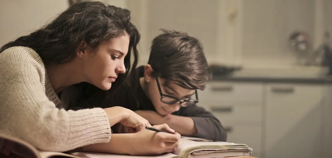 mom helping teenage son with learning differences do his homework