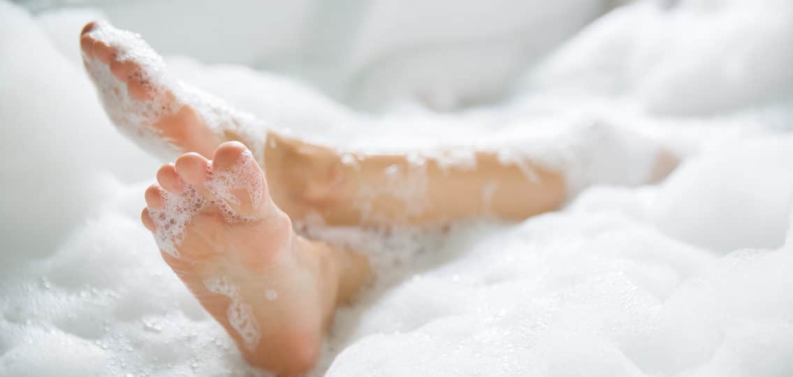 feet sticking out of a bubble bath