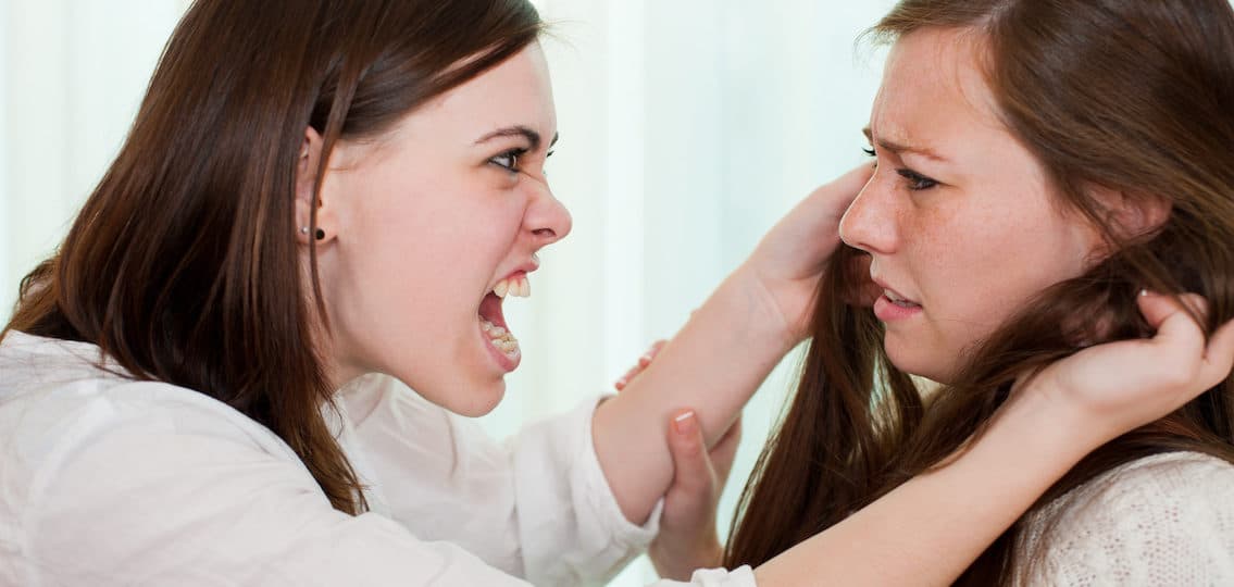 two teen sisters fighting and screaming one crying one angry