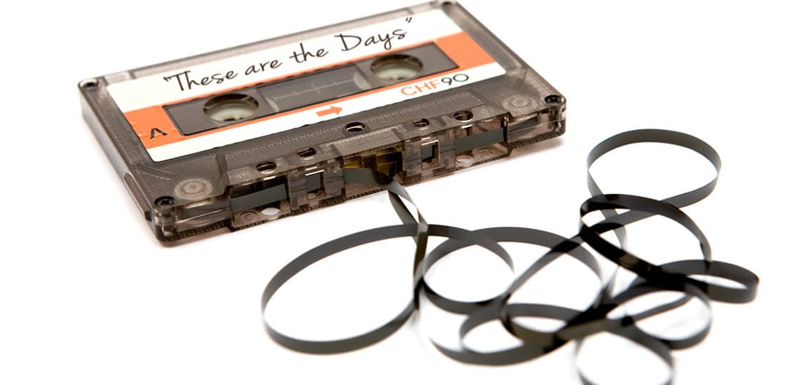 Run-down audio tape. White background. Selective focus. These are the Days written on the cassette