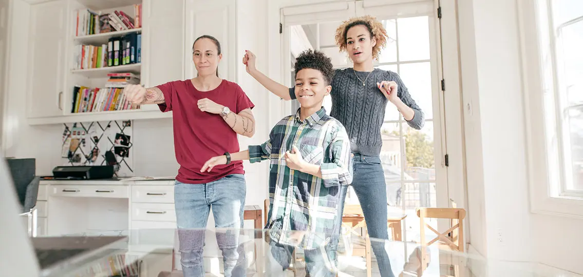 LGBTQ couple two moms honing their dancing skills with son.