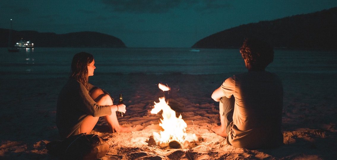 teenagers in summer around a campfire on the beach