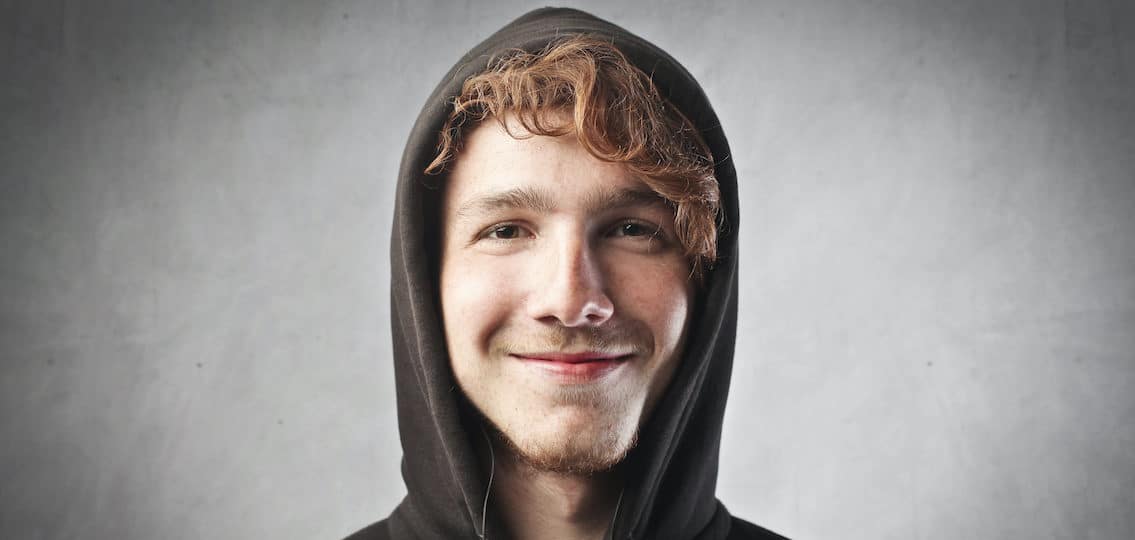 teen boy in hoodie with long curly hair and the beginnings of a beard