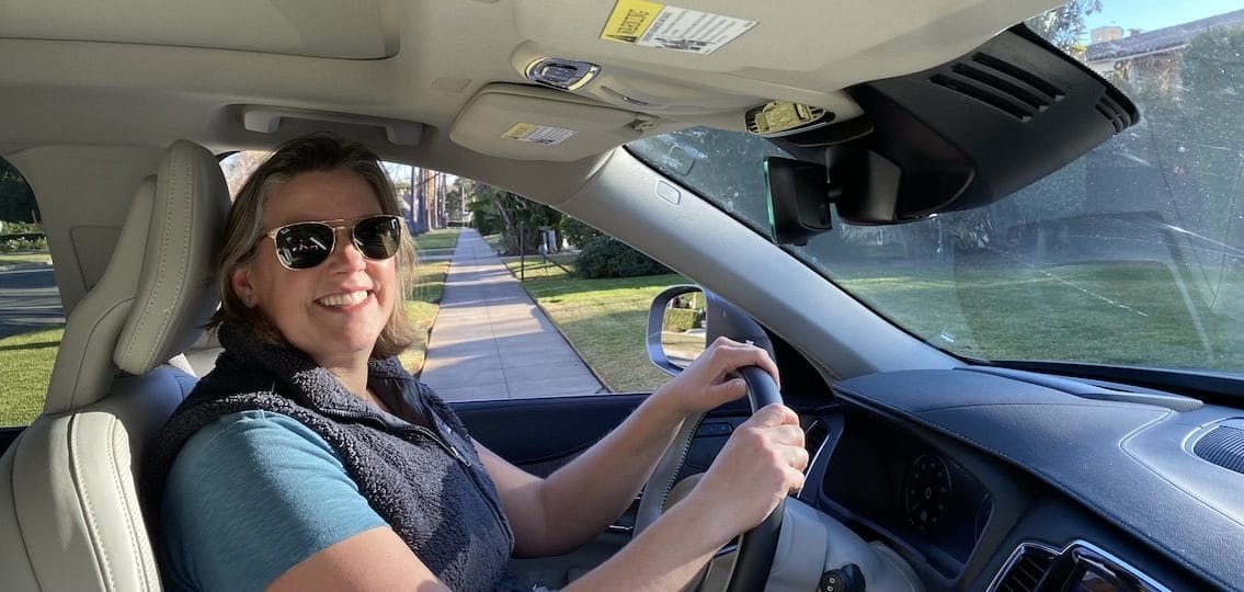 Author Emily Vitan Driving Alone in her car and smiling
