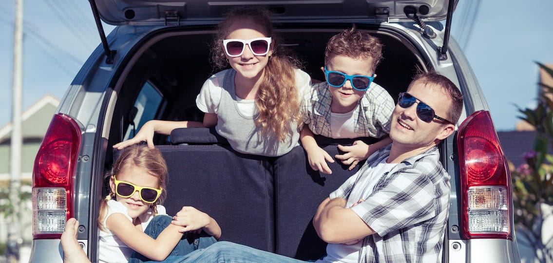 Happy family getting ready for road trip on a sunny day. Concept of friendly family.