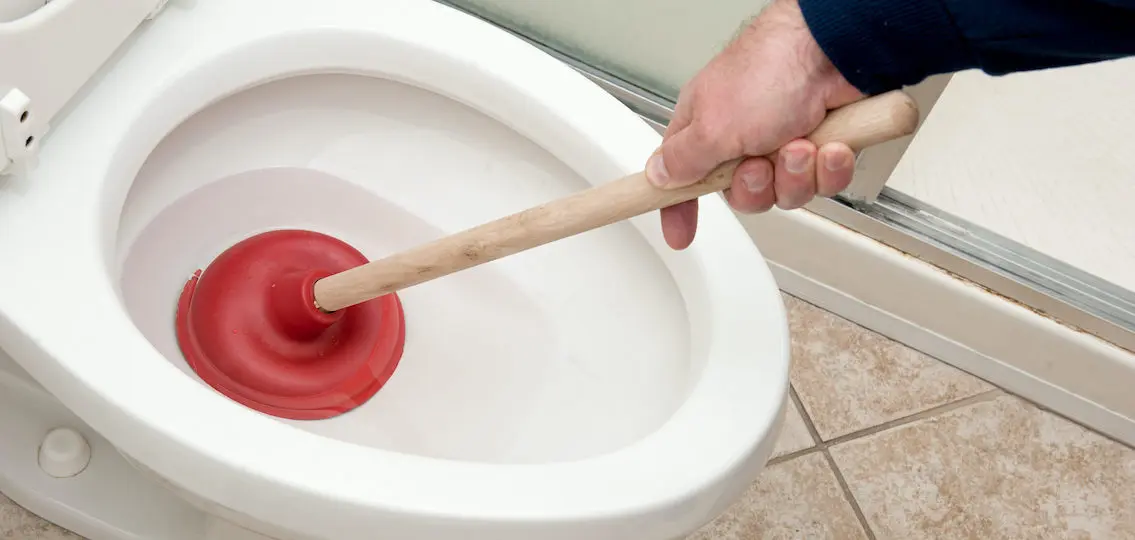 person learning how to plunge a toilet close up