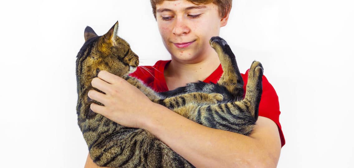 teen boy hugging with his cute cat