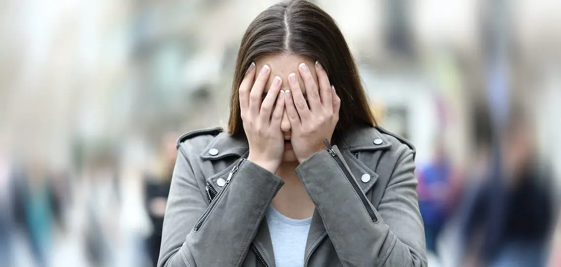 Front view of a teenage girl suffering re-entry anxiety on city street