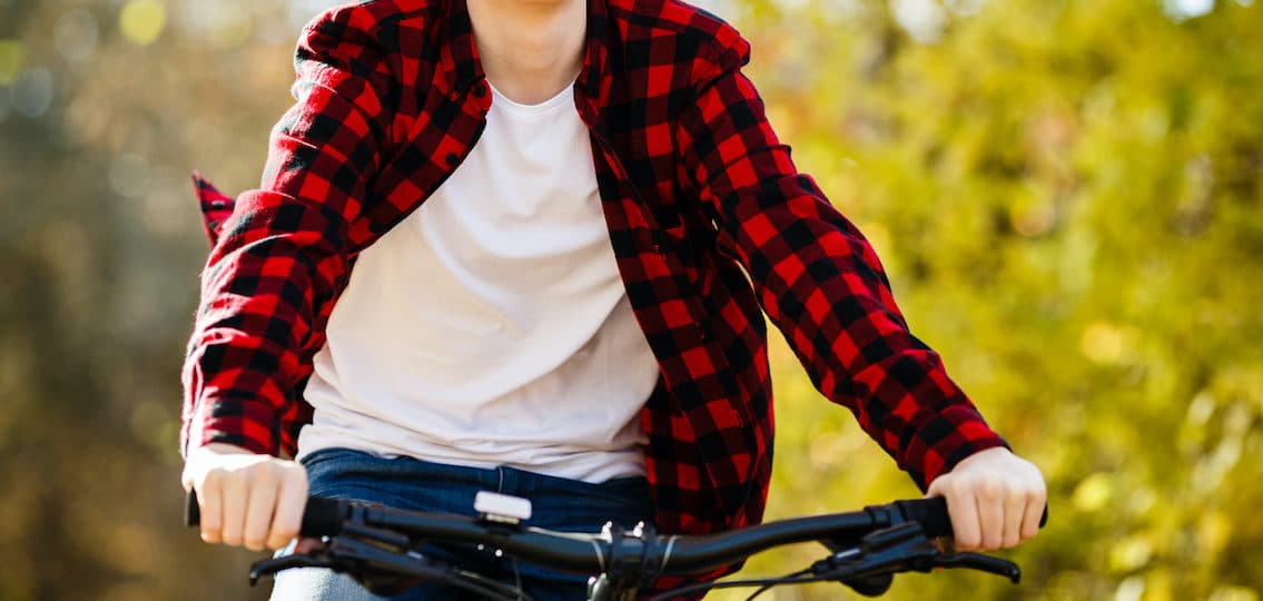 teenager riding his bike freely through the woods