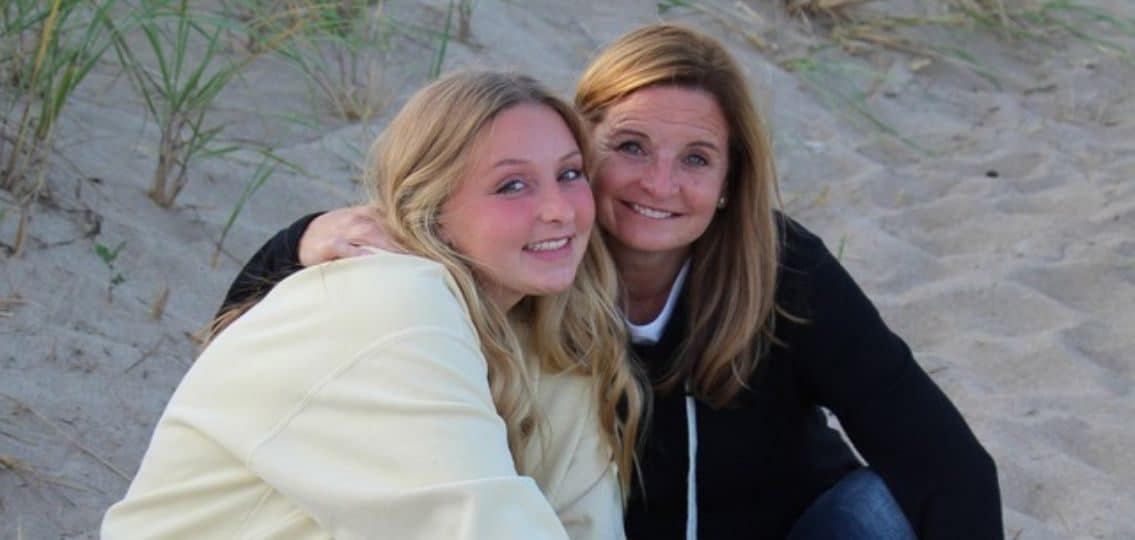 Author and her daughter hugging and smiling on the beach