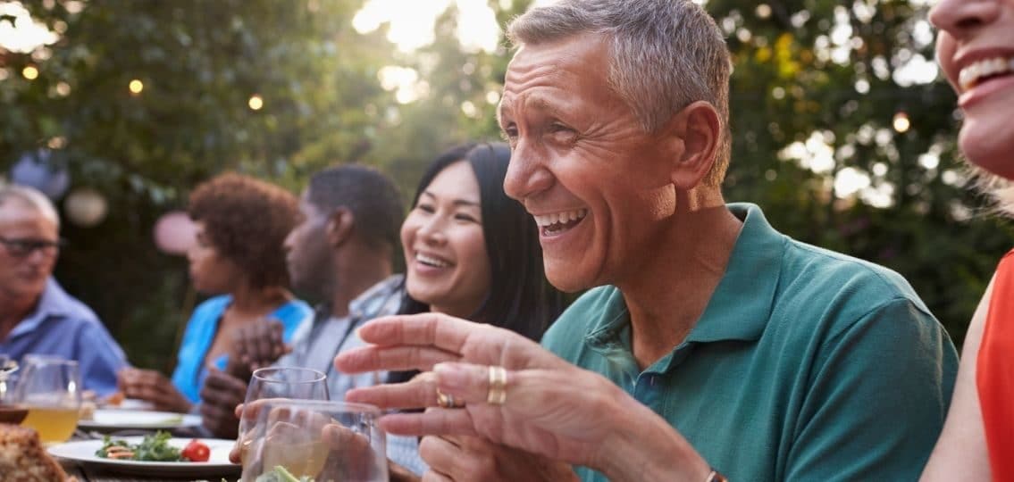 parents sitting outside at a dinner discussing saving for college