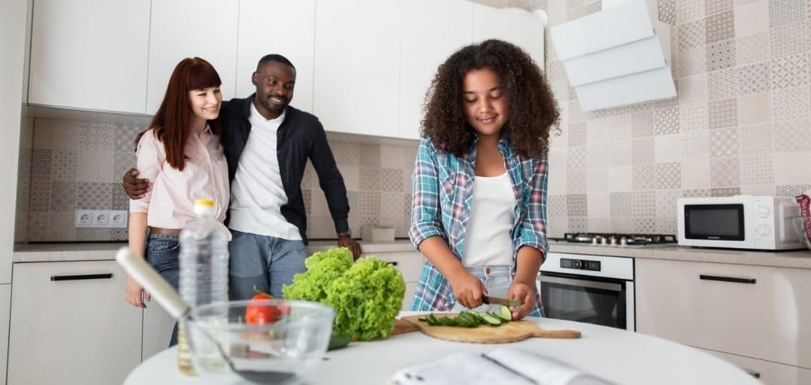tween girl cooking an easy meal while her parents watch and smile