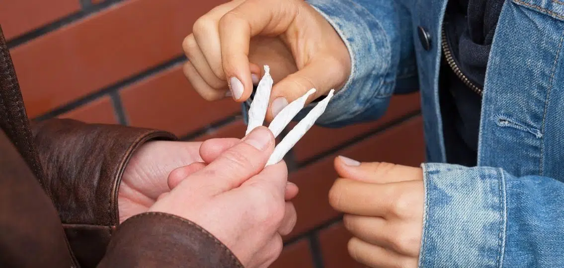 two teens sharing a marijuana joint close up on hands