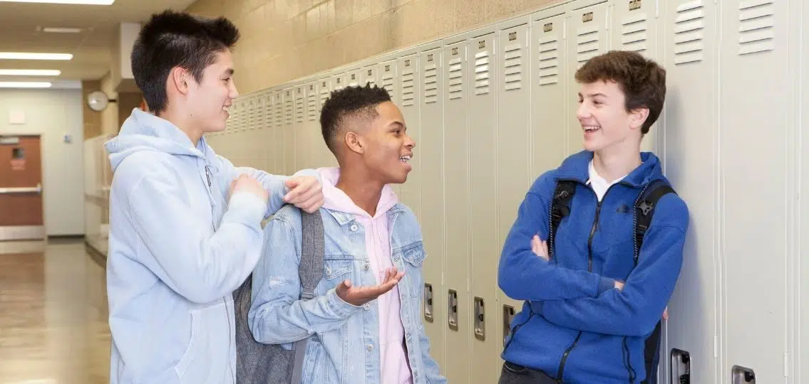 empowered teenage boys confident friends in front of lockers