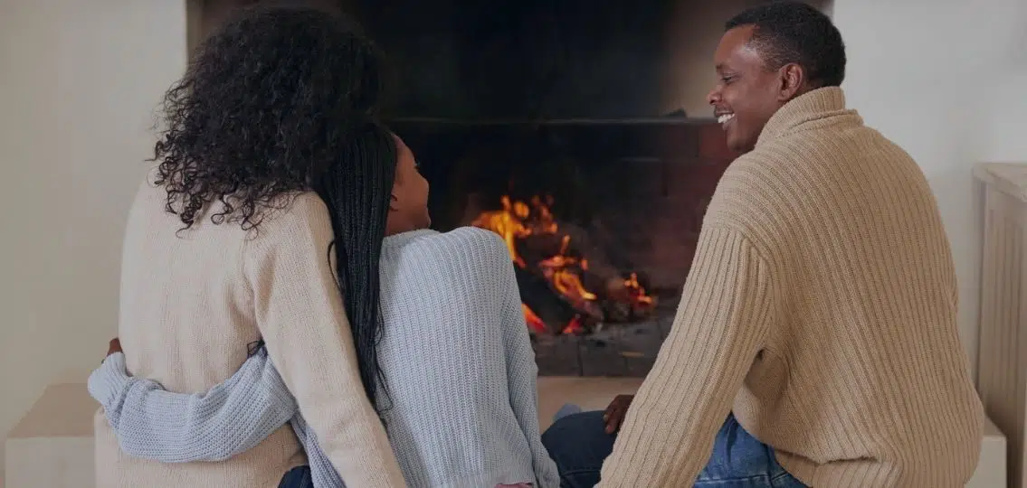 a family connecting with their teen in front of a fireplace at night