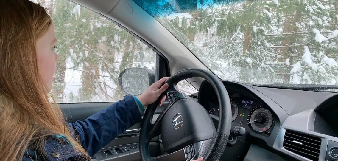 a teenager driving in the winter practicing winter driving safety tips