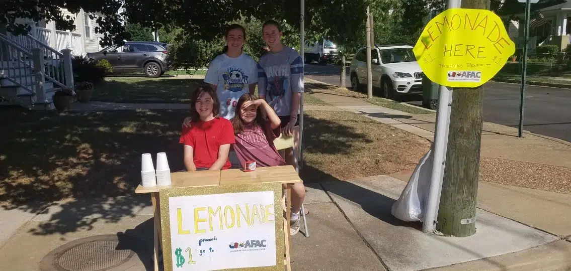 author's tweens in the summer at a lemonade stand