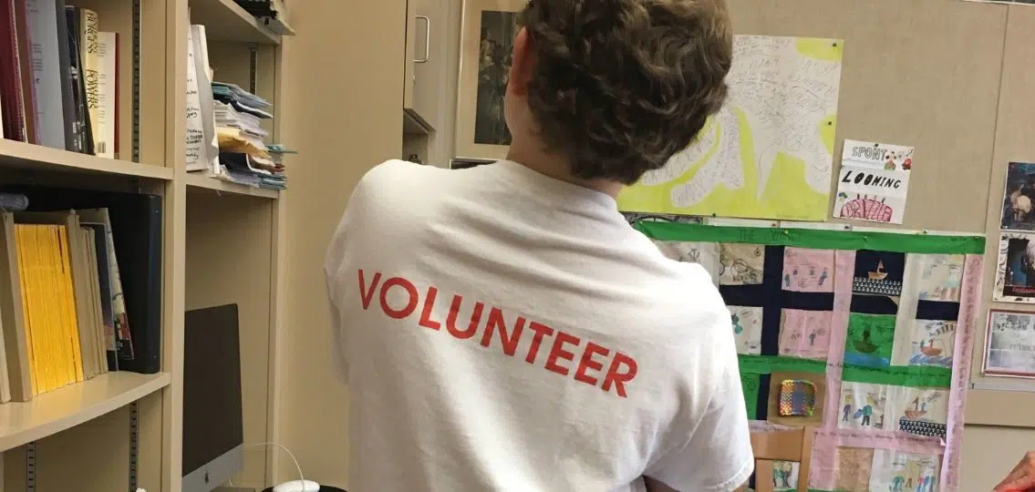 the author's teenage son in a shirt that says volunteer at his place of volunteering