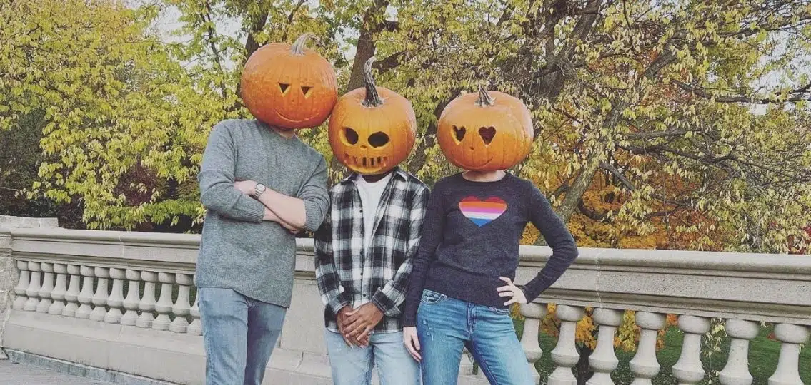 The Witt family taking their family halloween photos wearing pumpkin heads