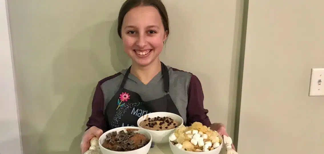 The author's teen daughter with a tray full of pms edible cookie dough