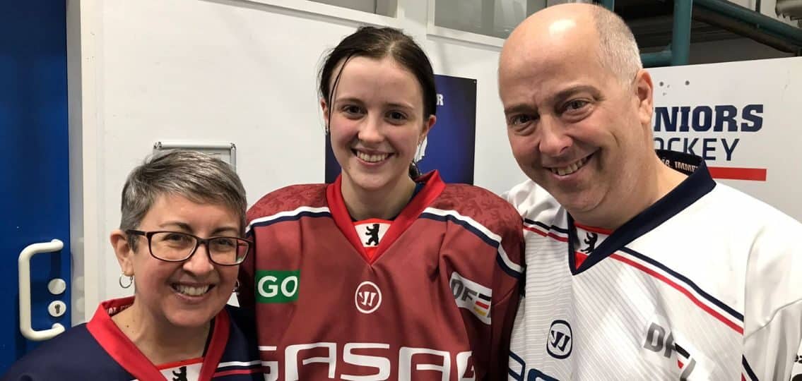A teenage girl at a hockey game with her father and grandmother, bonding with her grandmother