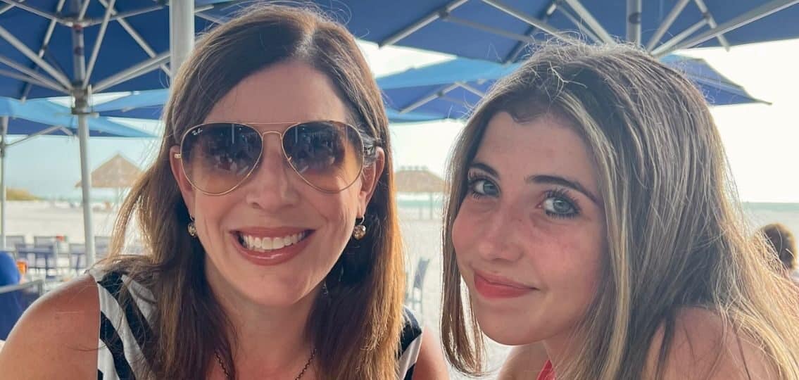 A mom and her daughter smiling together