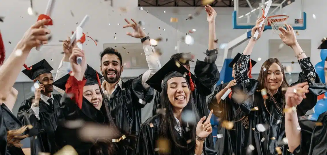 Teenagers celebrating high school graduation in the gym