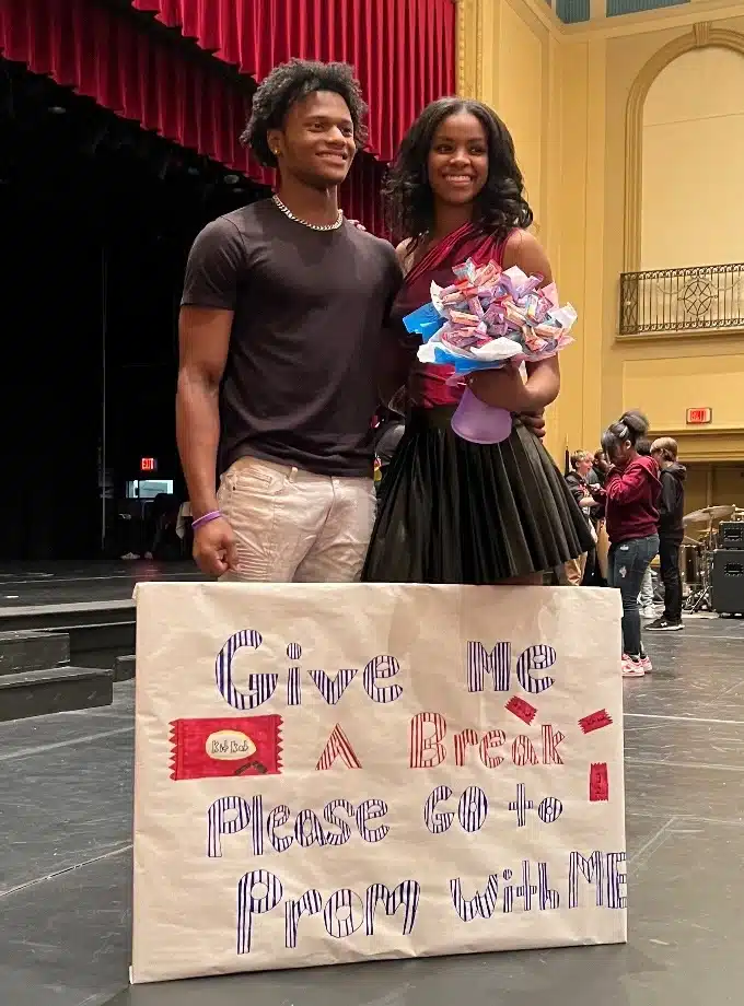 A guy with a promposal sign and the girl he asked to prom, the sign reads Give me A Break. Please Go to Prom With Me.