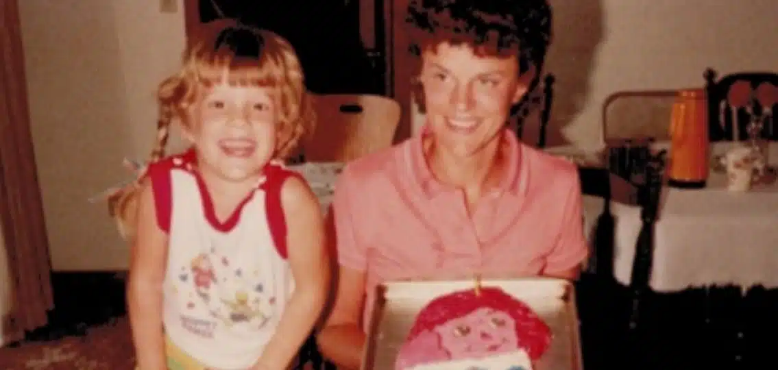 The author at a young age with her mother celebrating her birthday with a cake