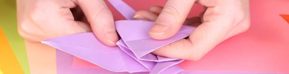 a close up of a teenager doing origami as a hobby