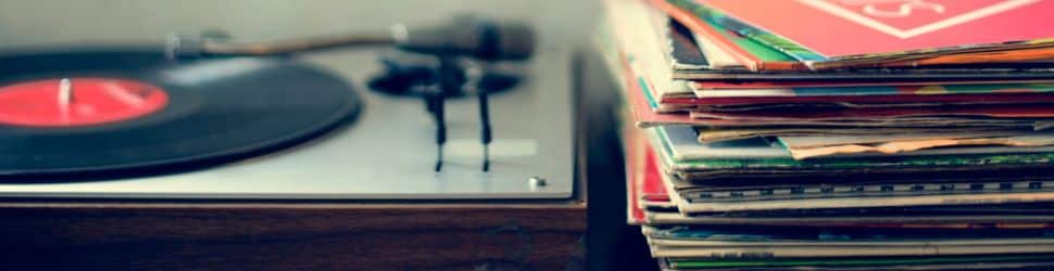 a close up of a vinyl record collection next to a record player