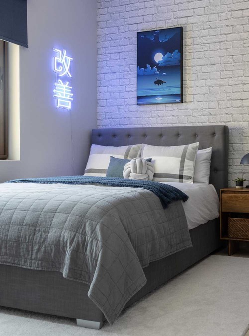 bedroom with white brick accent wall and blue neon light