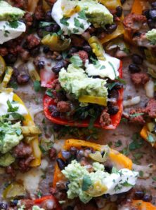 bell pepper slices topped with cheese, beans, sour cream, and guacamole