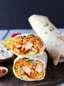 chicken, celery, avocado, cheese, lettuce, green onions and carrots wrapped in flour tortillas