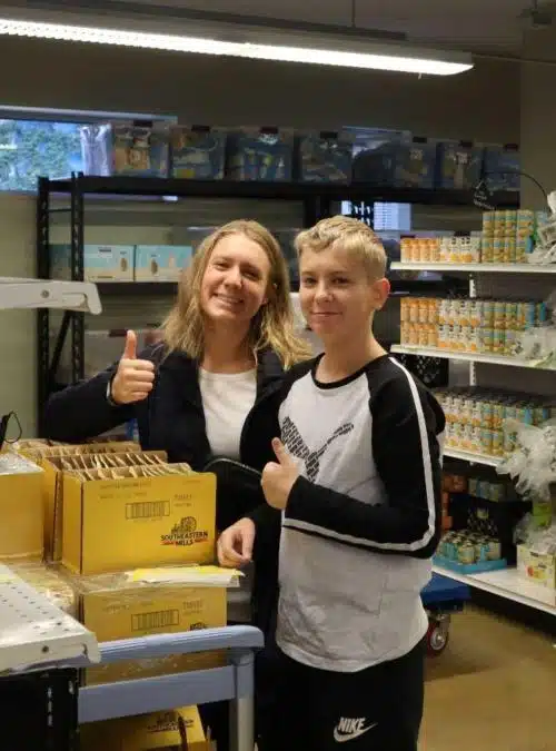 teen and mom volunteering in a food bank