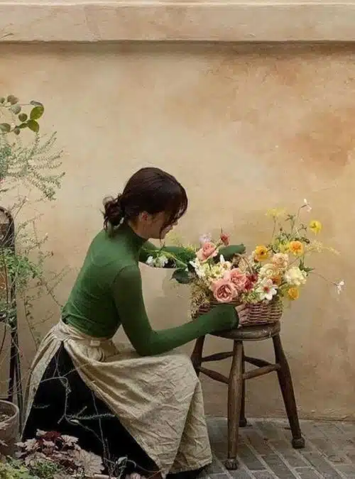 woman arranging flowers in a basket