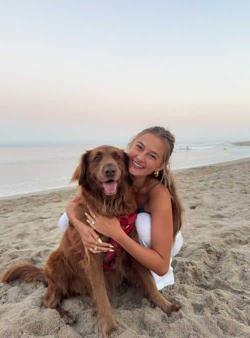 woman hugging her dog on a beach
