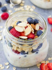 jar containing oatmeal topped with berries and nuts