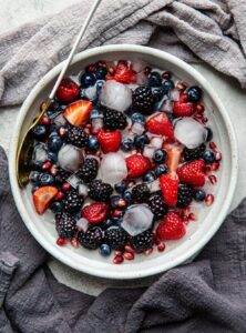 bowl of blueberries, blackberries, sliced strawberries, and ice cubes